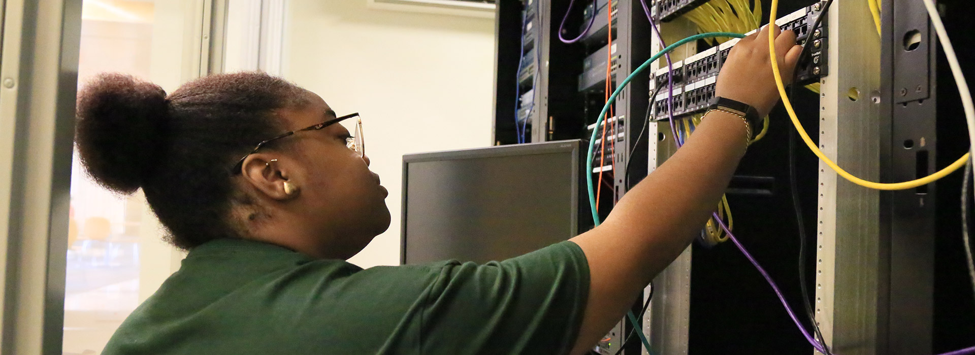 A student works on servers in the networking lab