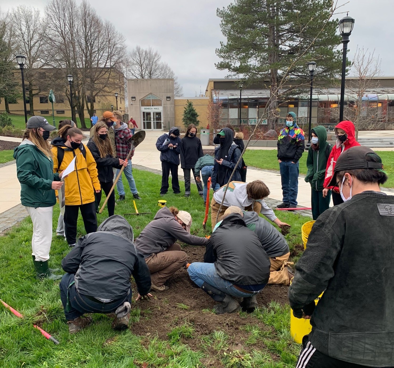 Faculty, staff and students plant a tree on campus in recognition of Arbor Day.