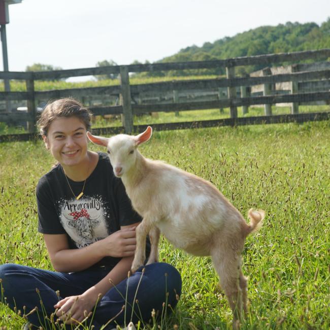 Carrianne Bush and a goat at the SUNY Morrisville livestock barn