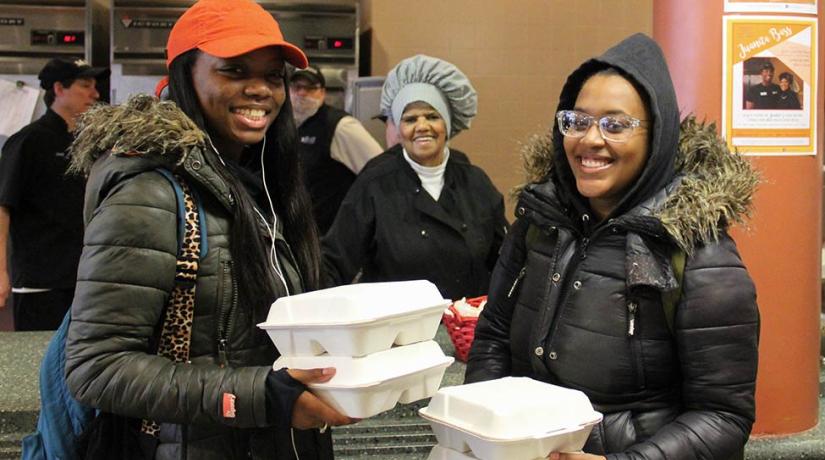 students holding takeout containers