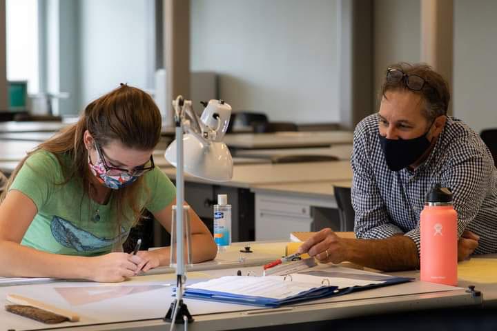 A faculty member in the Architectural Studies and Design program assists a student with a design project.