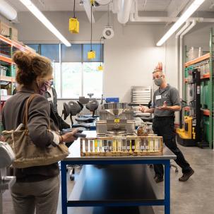 A faculty member gives visitors a tour of the Biomass Prep Lab.